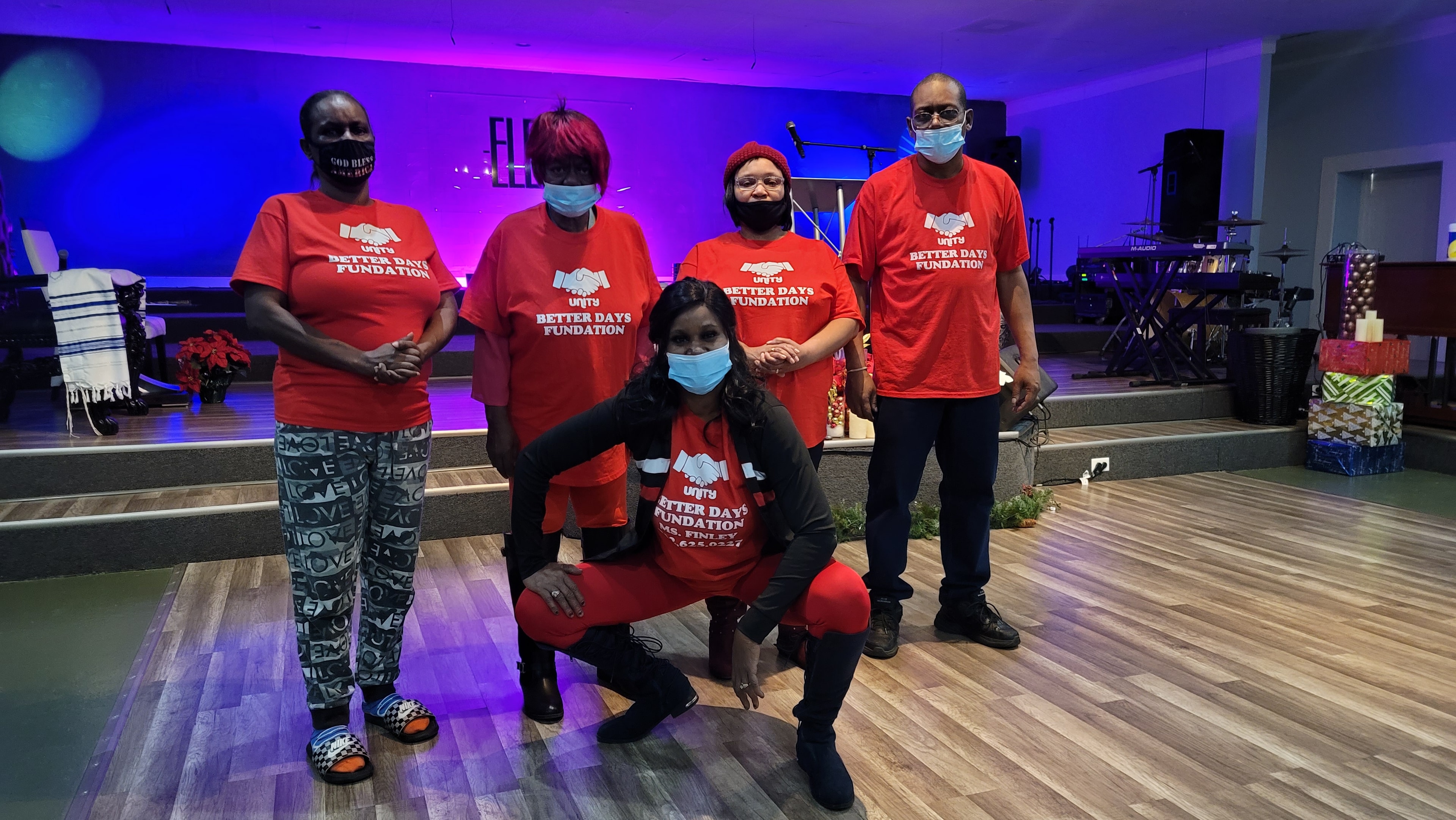 Better Days Foundation team members in red shirts at a community event